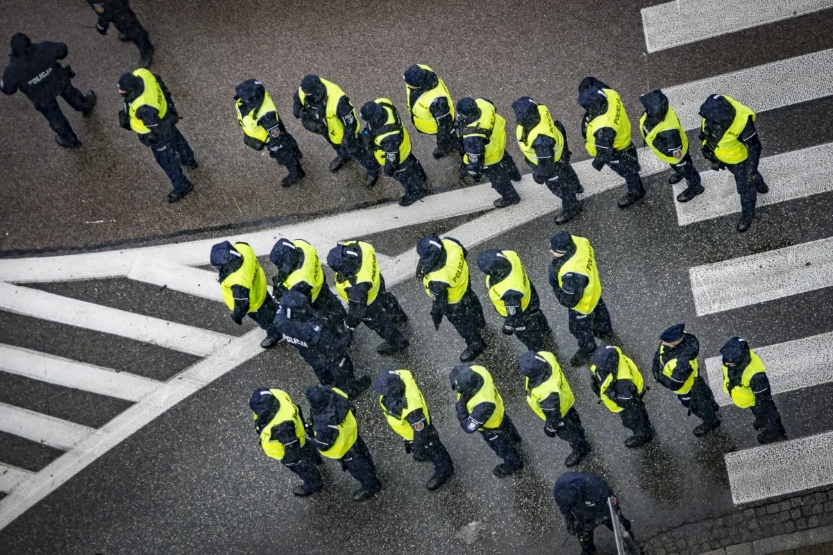 Formation of police in yellow vests crossing a zebra crossing
